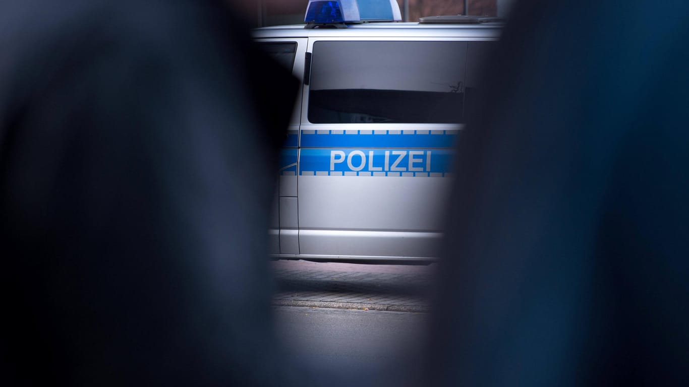 Zwei Polizisten stehen vor einem Einsatzwagen (Symbolbild): In Dortmund haben zwei Männer einen 23-Jährigen ausgeraubt.