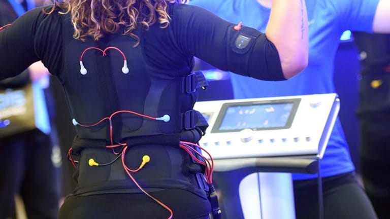 Bei EMS-Training tragen Sportlerinnen und Sportler eine verkabelte Weste und Manschetten, über die elektronische Impulse an den Körper weitergeleitet werden.