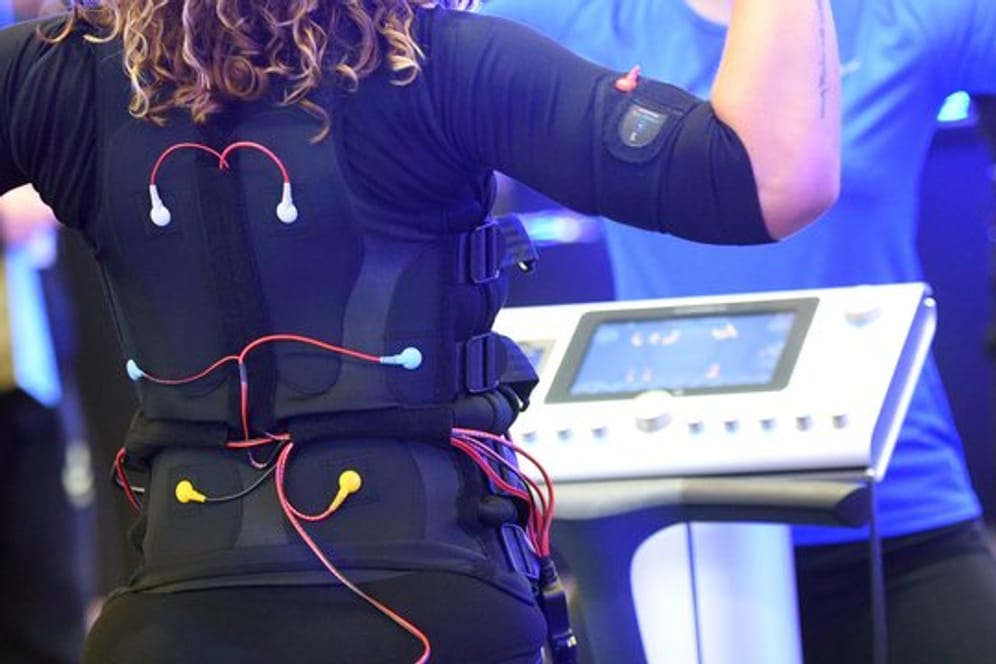 Bei EMS-Training tragen Sportlerinnen und Sportler eine verkabelte Weste und Manschetten, über die elektronische Impulse an den Körper weitergeleitet werden.