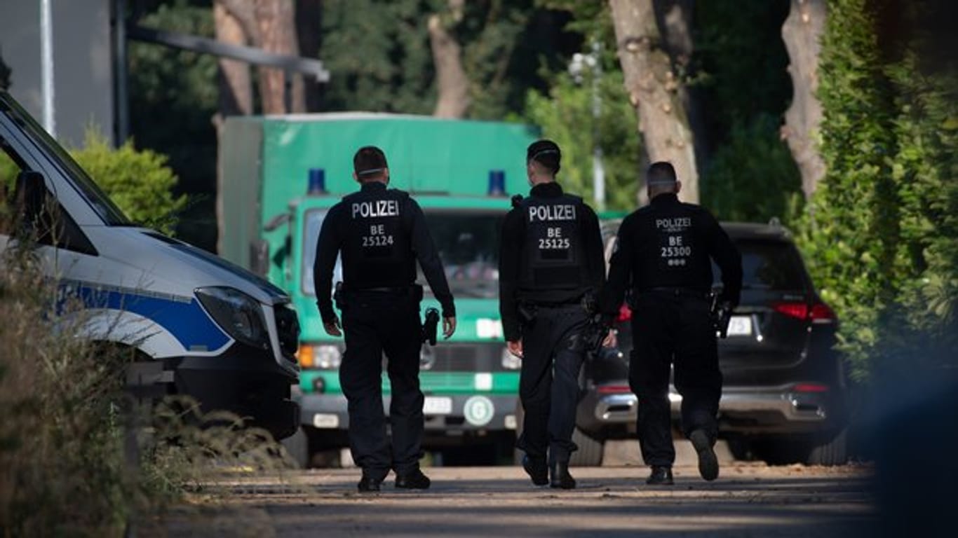 Polizeibeamte sind im Rahmen einer Durchsuchung auf einem Grundstück in Brandenburg unterwegs.