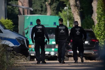 Polizeibeamte sind im Rahmen einer Durchsuchung auf einem Grundstück in Brandenburg unterwegs.