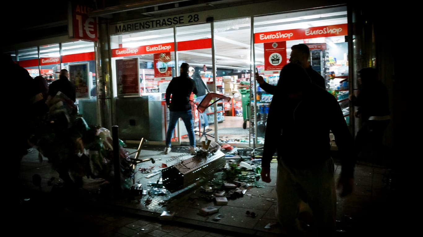 Menschen stehen vor einem geplünderten Geschäft in der Marienstraße: Dutzende gewalttätige Kleingruppen haben die Innenstadt verwüstet.