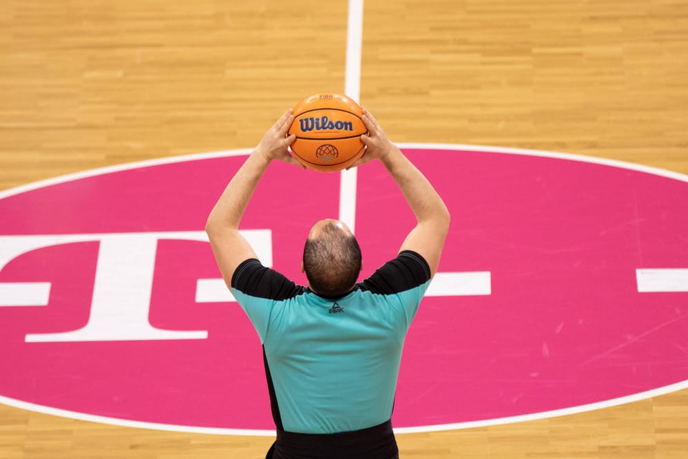 Ein Schiedsrichter hält einen Basketball nach oben (Symbolbild): Die Telekom Baskets begrüßen ihren neuen Trainer.