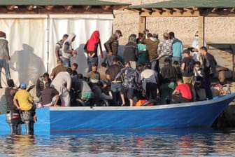 Migranten verlassen nach der Ankunft im Hafen von Lampedusa ihr überfülltes Boot: Auf der italienischen Insel hat die Zahl der Ankünfte in diesem Sommer wieder zugenommen.