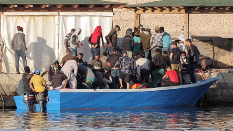Migranten verlassen nach der Ankunft im Hafen von Lampedusa ein überfülltes Boot.