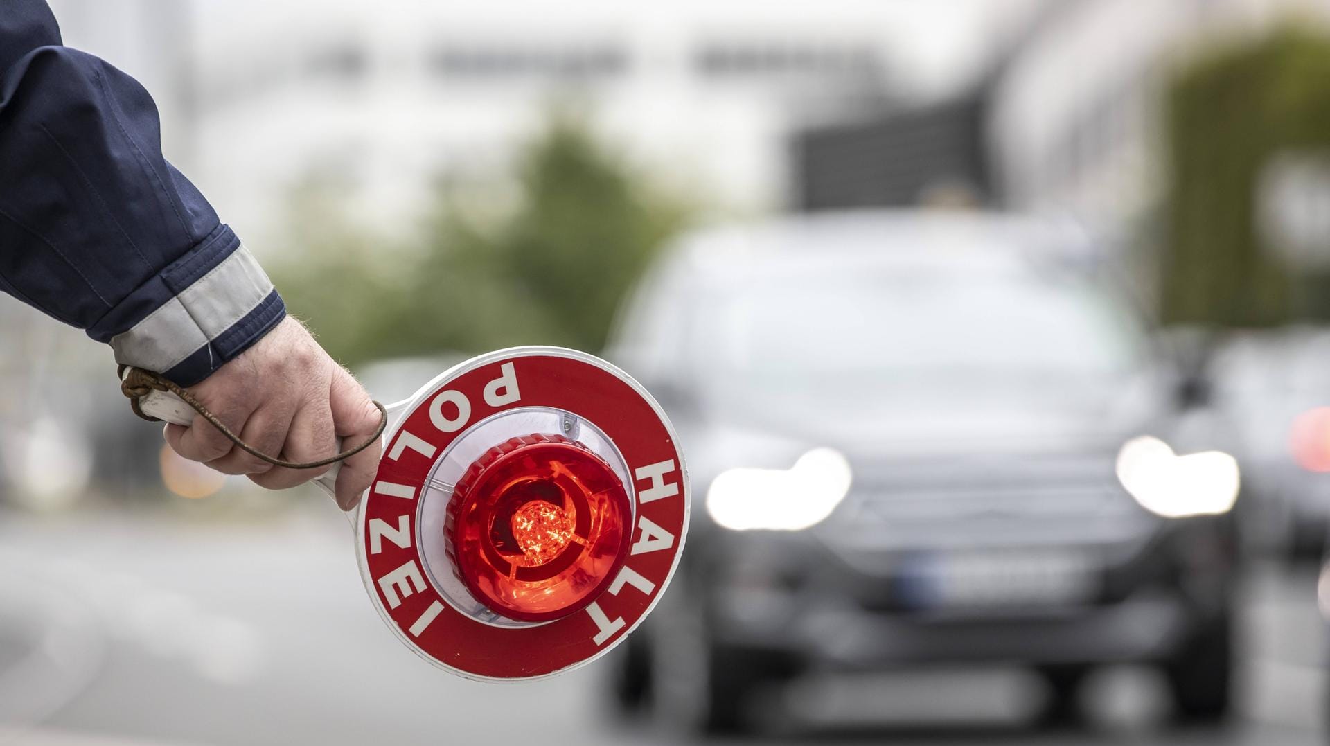 Ein hält einen Anhaltekelle in der Hand (Symbolbild): In Köln hat sich ein Jugendlicher eine Verfolgungsjagd mit der Polizei geliefert. Ein hält einen Anhaltekelle in der Hand (Symbolbild): In Köln hat sich ein Jugendlicher eine Verfolgungsjagd mit der Polizei geliefert.