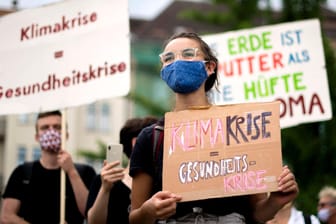 Demonstranten halten Schilder in den Händen (Sybolbild): Umweltschützer wollen am Freitag in Kiel eine Fahrraddemonstration abhalten.