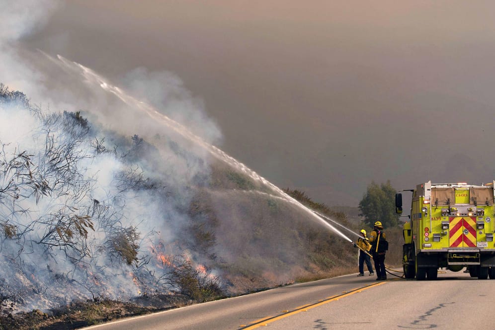 Einsatzkräfte der Feuerwehr löschen einen Brand: Seit Mitte August wüten an der US-Westküste Dutzende Feuer.