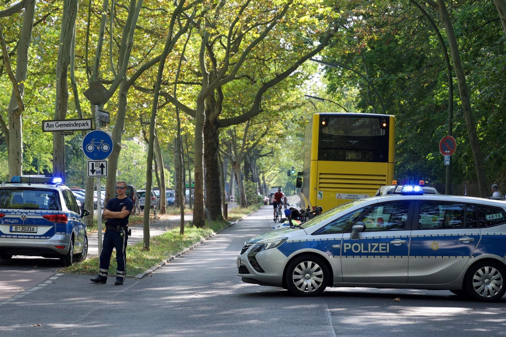 Polizisten stehen an einer Straße: In der Nähe ist an einer Oberschule Amokalarm ausgelöst worden.