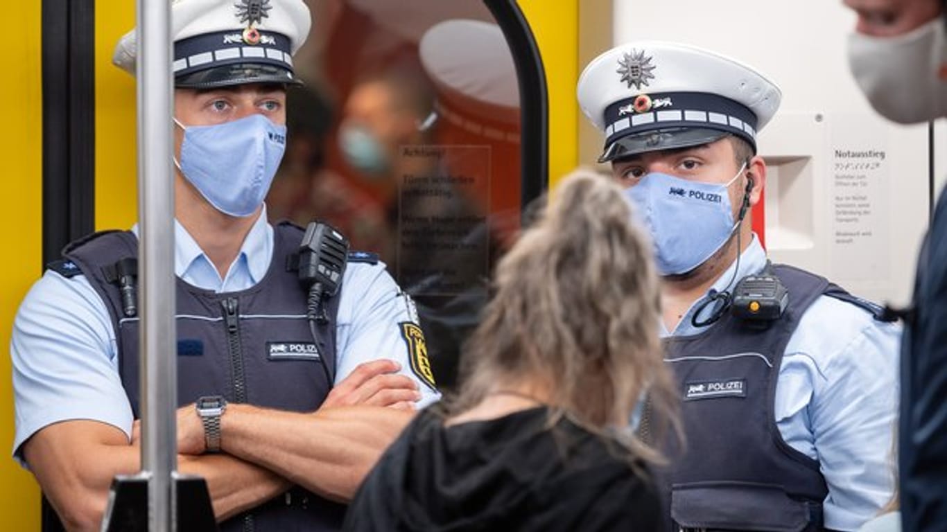 Polizeibeamte kontrollieren in einer Stuttgarter U-Bahn die Einhaltung der Maskenpflicht.