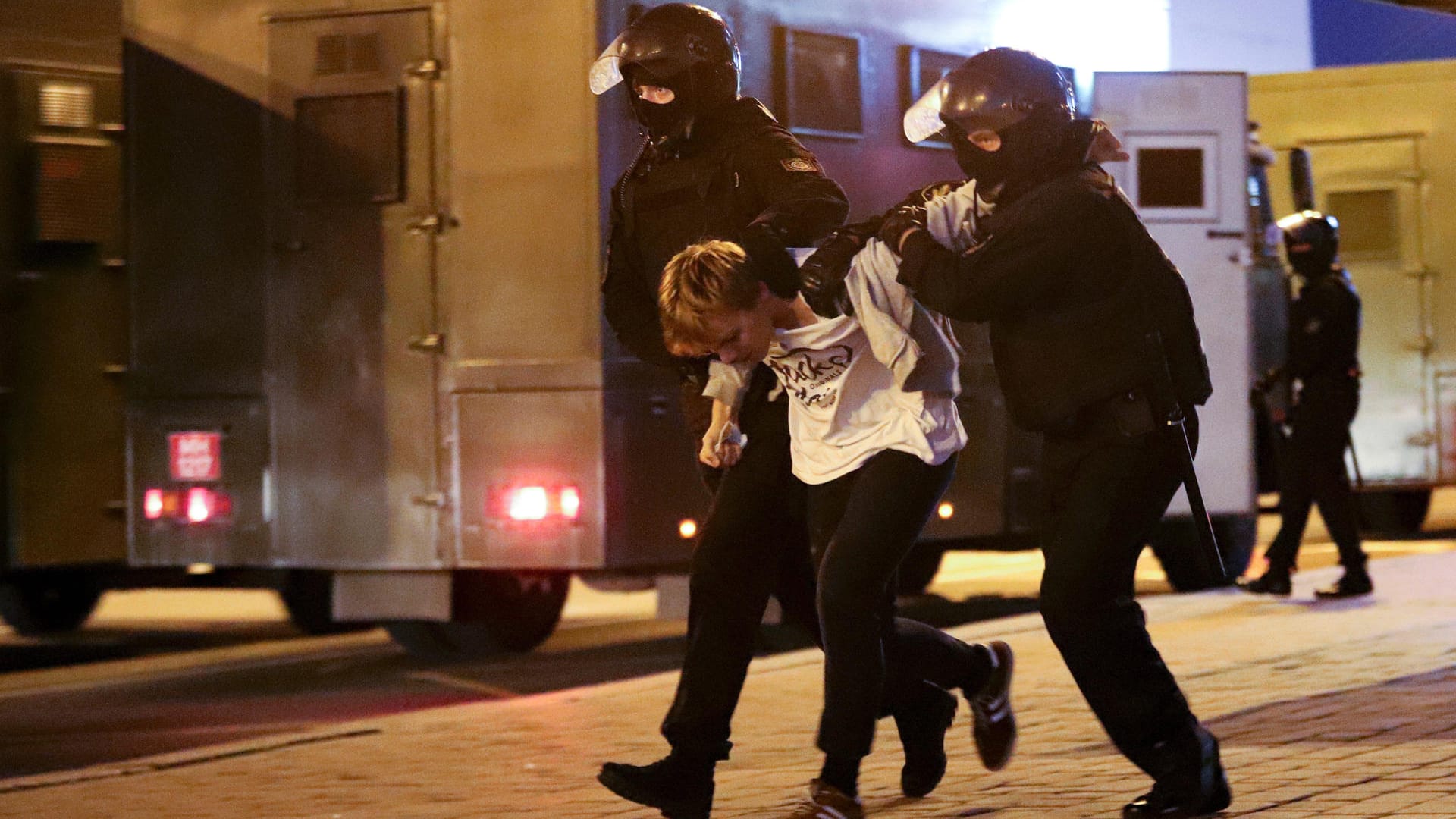 Polizisten halten einen verhafteten Demonstranten fest: Auf Videos war zu sehen, wie Sicherheitskräfte sich auf Straßen positionierten und die Menschen zurückdrängten.