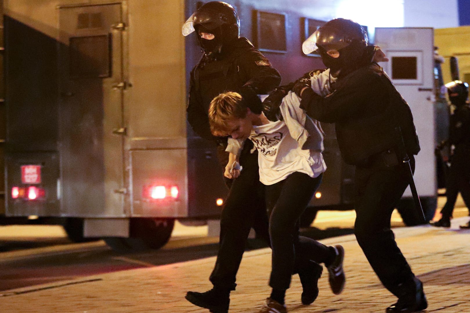 Polizisten halten einen verhafteten Demonstranten fest: Auf Videos war zu sehen, wie Sicherheitskräfte sich auf Straßen positionierten und die Menschen zurückdrängten.