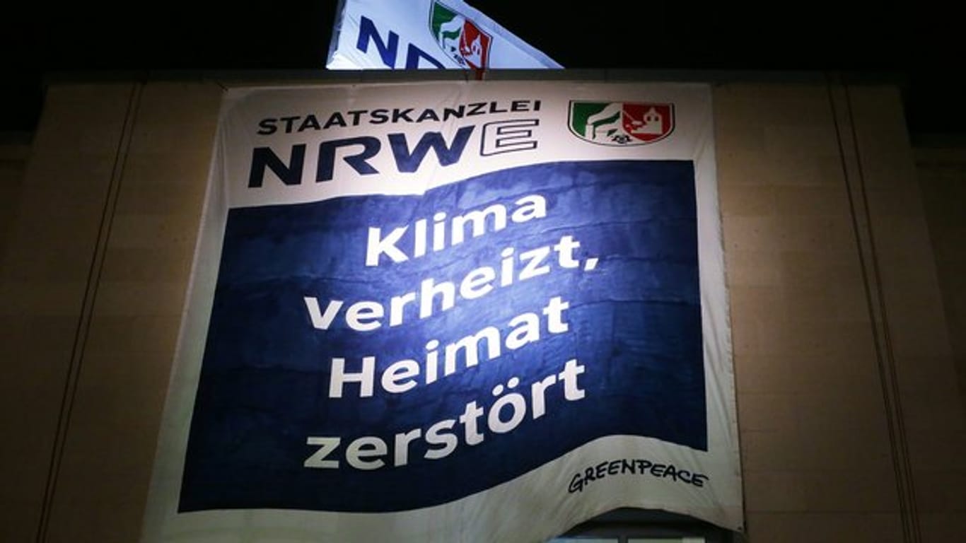 Greenpeace Aktivisten haben am Düsseldorfer Staatskanzlei zwei Banner aufgespannt.