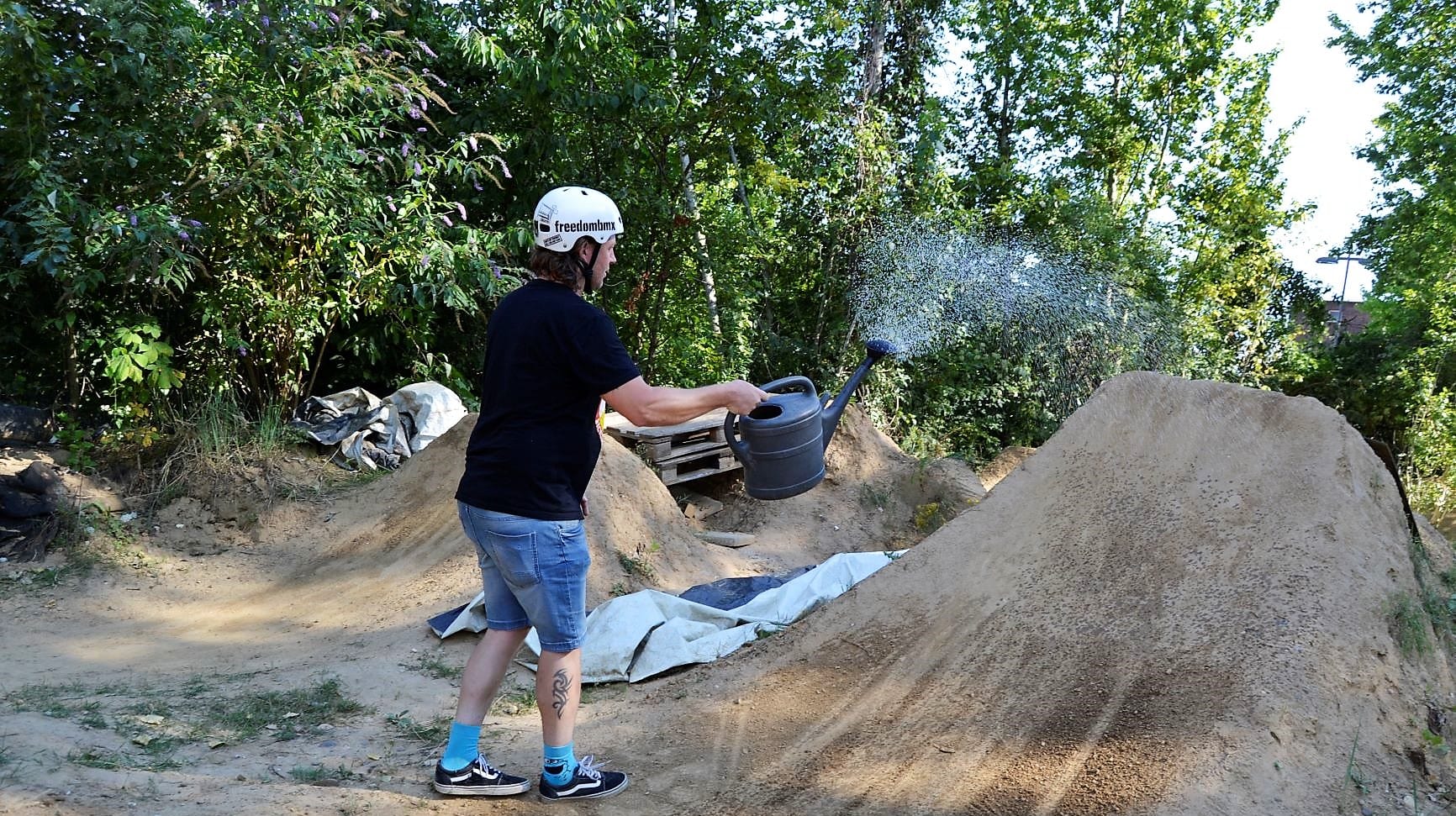 Ein junger Mann wässert eine Rampe: Die Dirt Biker haben ihren Parcours bisher selbst gepflegt.