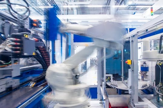 Ein Industrieroboter nimmt unter Reinraumbedingungen einen Halter für Insulinspritzen in einer Produktionshalle eines neu errichteteten Werks des Schweizer Medizintechnikunternehmens Ypsomed aus einer Maschine.