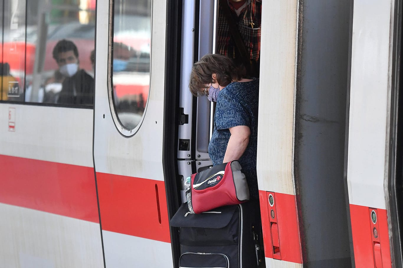 Eine Frau steigt mit Gepäck aus einem ICE (Symbolbild): In München wurde einer Frau von einer ICE-Tür die Fingerkuppe abgetrennt.