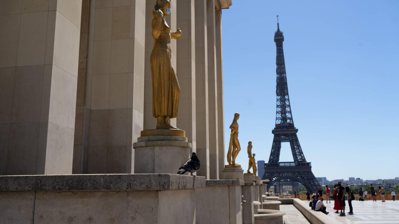 Touristen in der Nähe vom Eifelturm in Paris: Auf den Straßen gilt eine Maskenpflicht.
