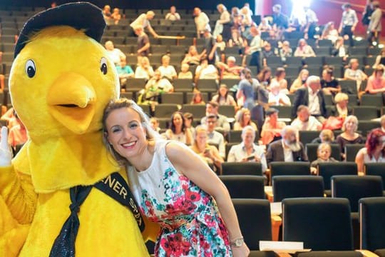 Nicola Jones, Leiterin des Kindermedienfestivals "Goldener Spatz", Arm in Arm mit dem Festival-Maskottchen.