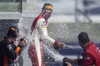 Formel-2-Pilot Mick Schumacher (M) feiert seinen Sieg in Sotschi mit Champagner.