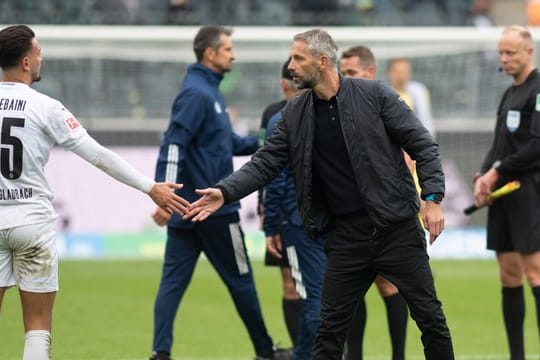 Gladbach-Trainer Marco Rose (r) klatscht nach dem 1:1 Ramy Bensebaini ab.