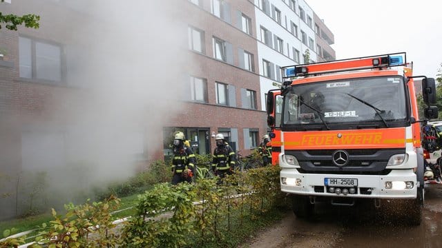 Feuerwehrleute sind vor einem Gebäude im Einsatz Feuerwehrleute sind vor einem Gebäude im Einsatz