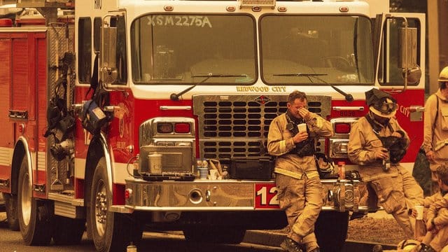 Feuerwehrmänner ruhen sich an ihrem Einsatzwagen aus, nachdem sie in der Nacht gegen das "Glass"-Feuer gekämpft haben. Feuerwehrmänner ruhen sich an ihrem Einsatzwagen aus, nachdem sie in der Nacht gegen das "Glass"-Feuer gekämpft haben.