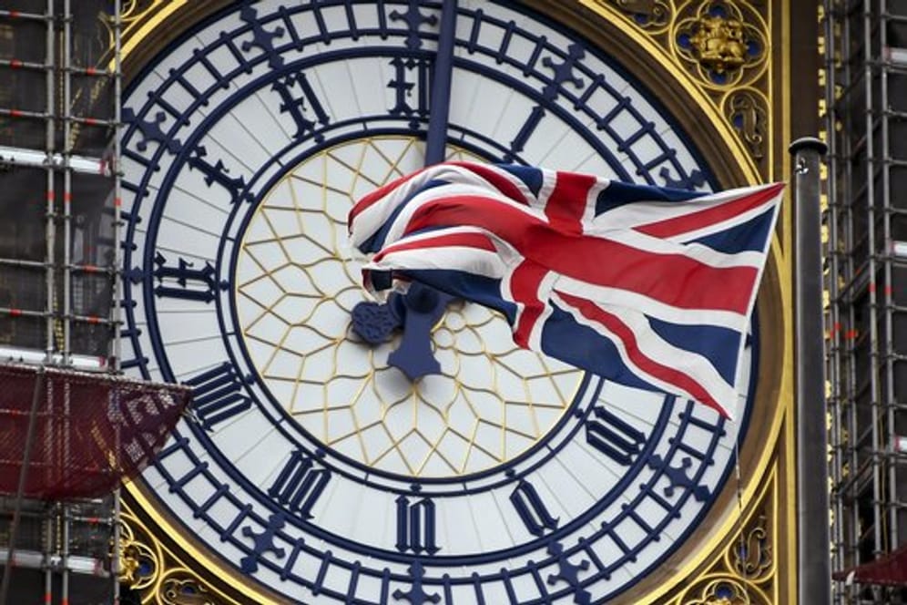 Eine am Ziffernblatt des Big Ben befestigte britische Flagge weht im Wind.