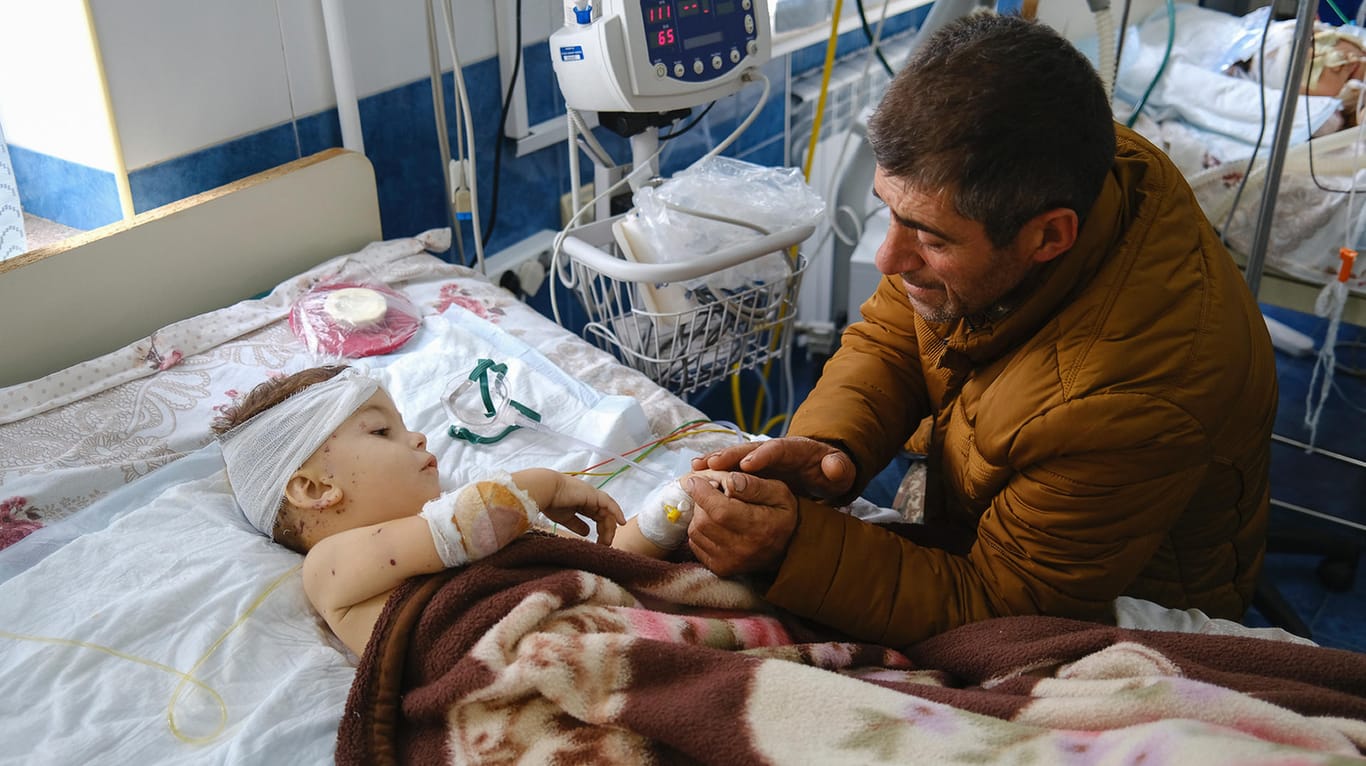 Ein Mann im aserbaidschanischen Stepanakert mit seinem verletzten Kind.