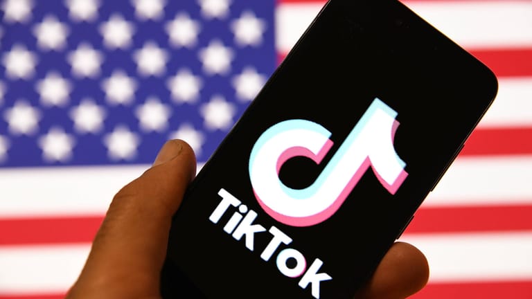Das Logo von TikTok mit US-Flagge im Hintergrund (Symbolbild): Ein Richter sieht rechtliche Probleme bei Trumps Vorgehen gegen TikTok.