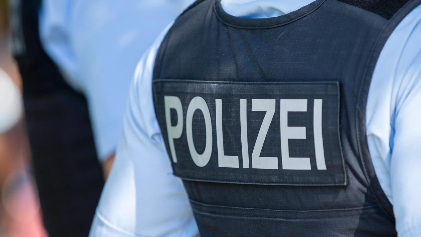 Polizist von hinten (Symbolbild): In Hagen hat ein Mann drei weitere mit einem Metallrohr attakiert.