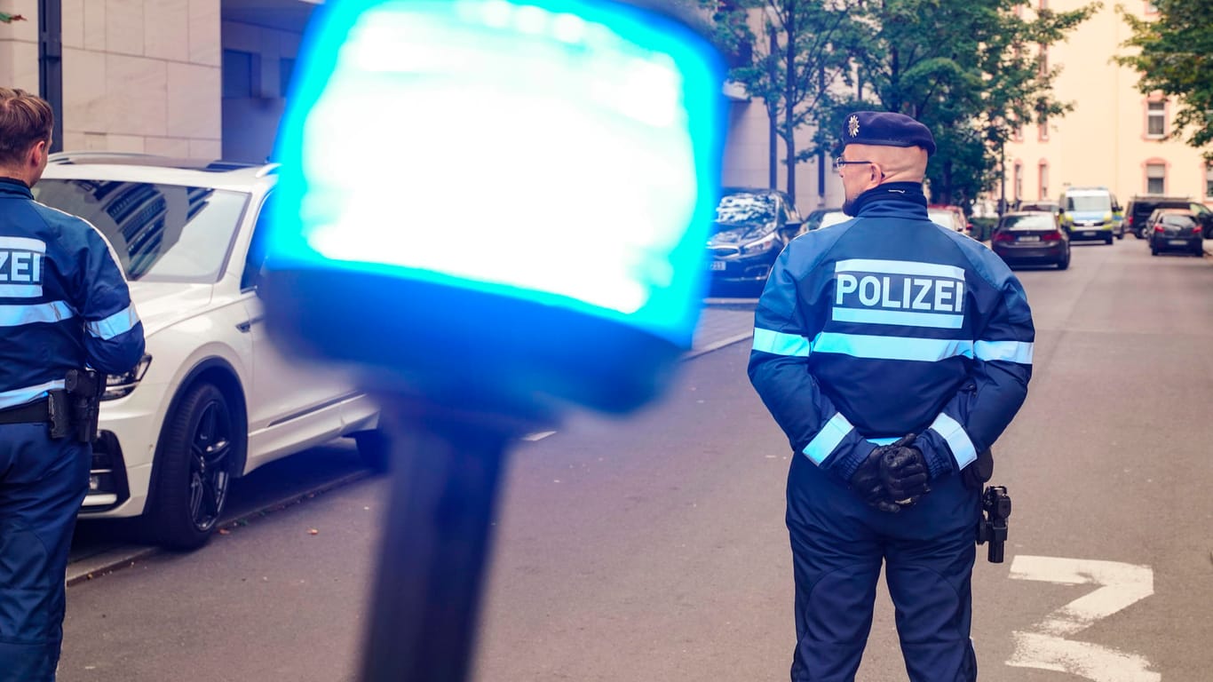 Zwei Polizisten sperren die Straße ab: In Frankfurt sind für einen SEK-Einsatz mehrere Straßen abgeriegelt worden.
