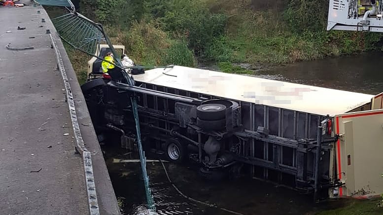 In den Fluss gestürzter Lkw: Ein Passant kam dem Fahrer zu Hilfe.