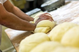 Bäcker knetet Teig (Symbolbild): Die Großbäckerei Sternenbäck schließt viele Filialen.