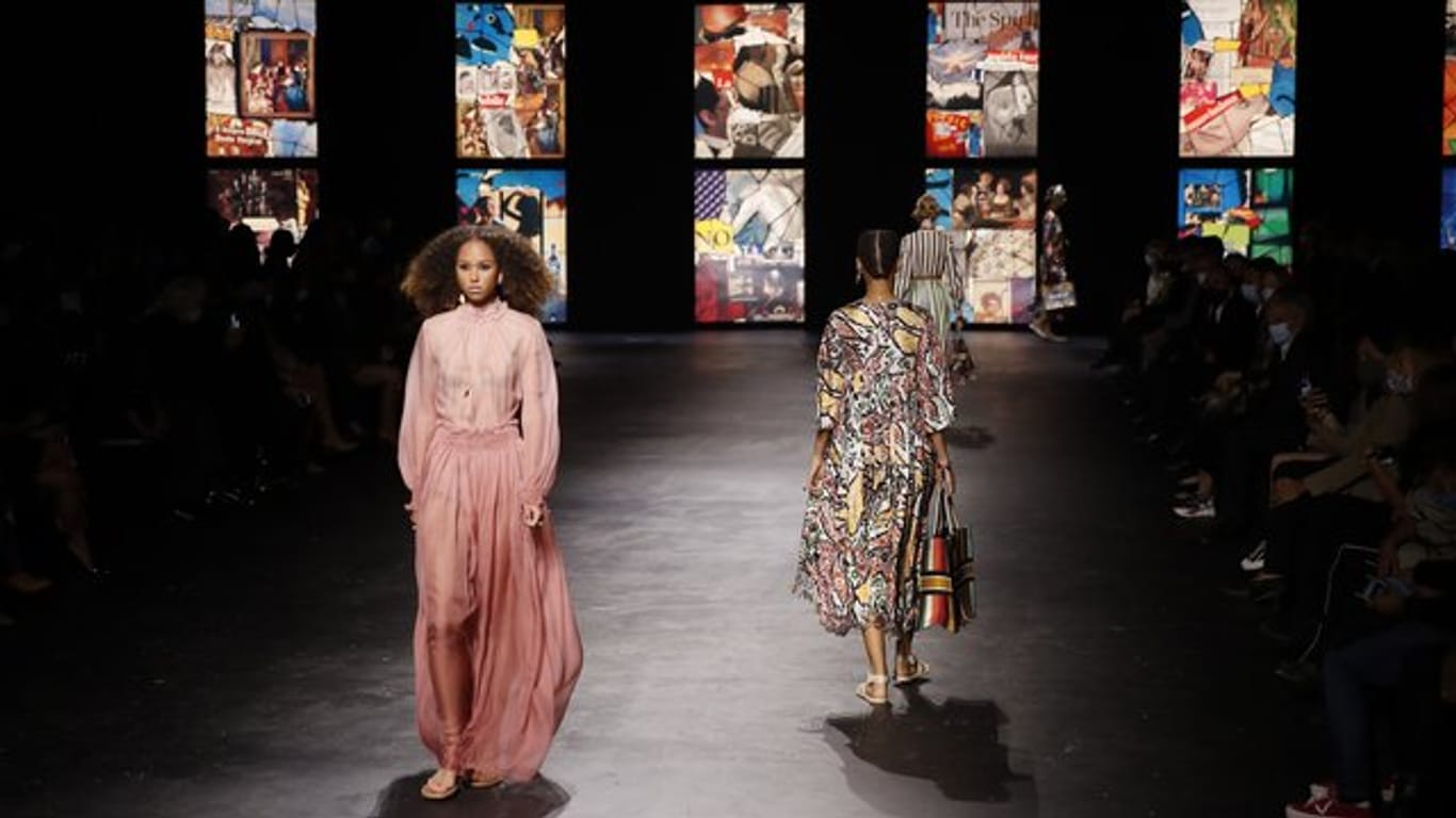 Models zeigen sehr feminine Kleider auf dem Dior-Laufsteg.