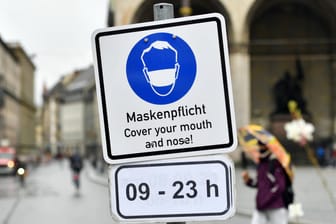 Ein Schild weist auf die Maskenpflicht am Odeonsplatz in München hin: Die Maskenpflicht wird aufgrund des stabilen Infektionsgeschehens vorerst wieder aufgehoben.
