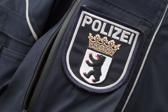 Das Wappen der Berliner Polizei prangt an einer Jacke (Symbolbild): Eine Gruppe von Polizisten soll sich in einer Chatgruppe rassistisch geäußert haben.