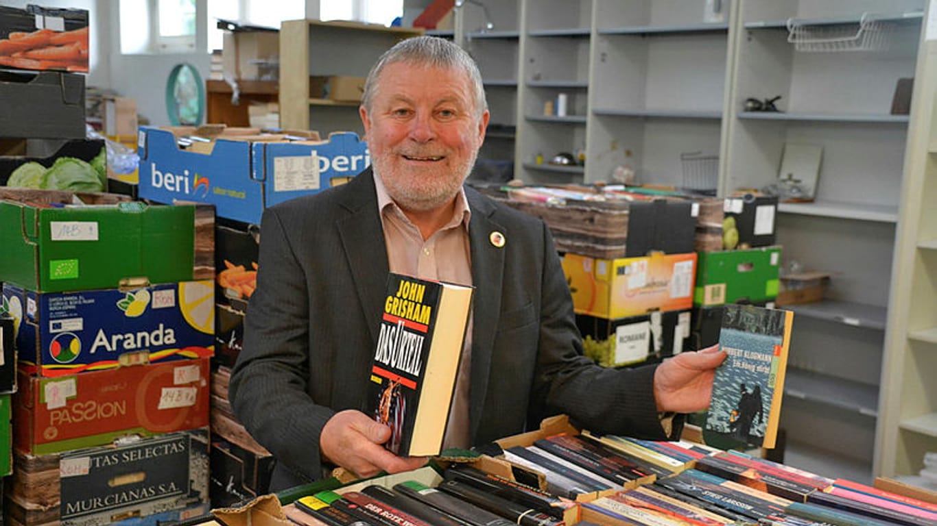Peter Schümann vor einem Haufen Bücher: Im Lager des Büchervereins stapeln sich bis zu 16.000 Exemplare.