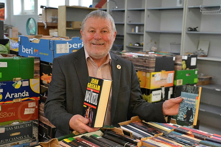 Peter Schümann vor einem Haufen Bücher: Im Lager des Büchervereins stapeln sich bis zu 16.000 Exemplare.