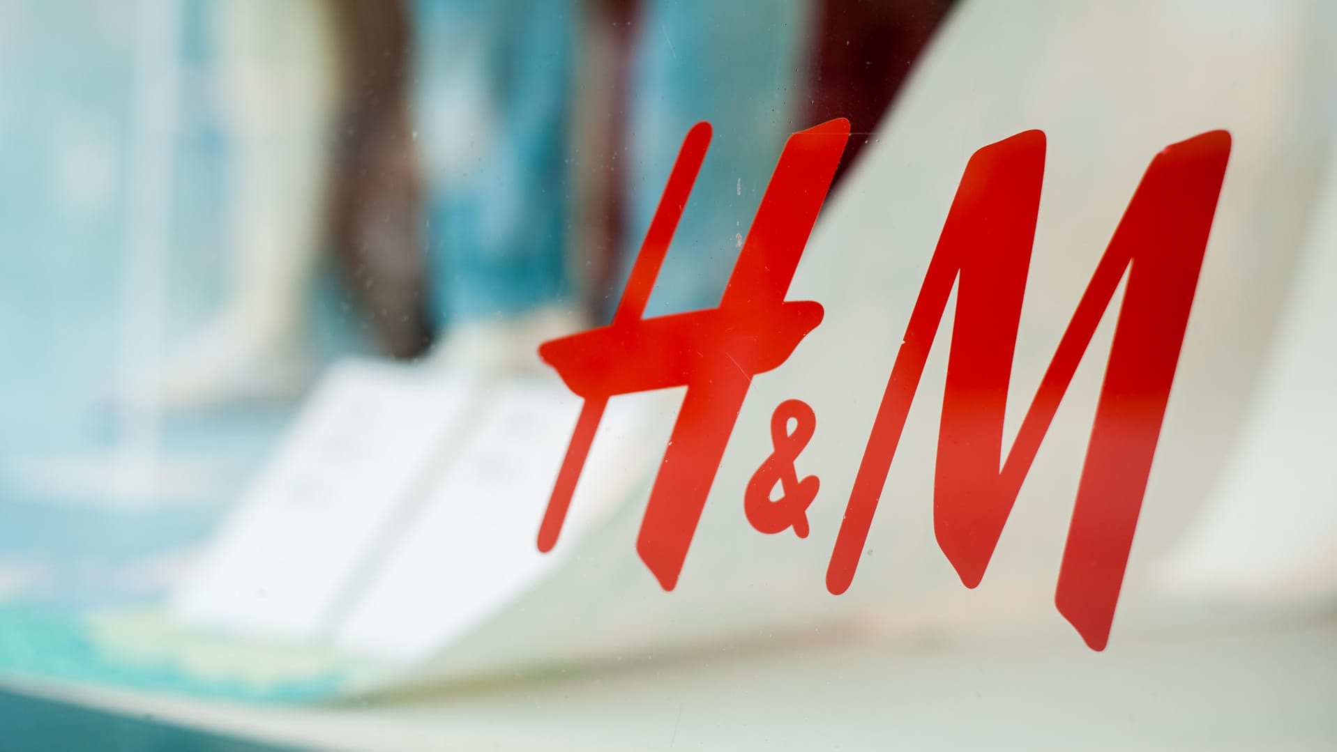 Das H&M-Logo auf einem Schaufenster (Symbolbild): Die Corona-Pandemie hat die Modeindustrie hart getroffen.