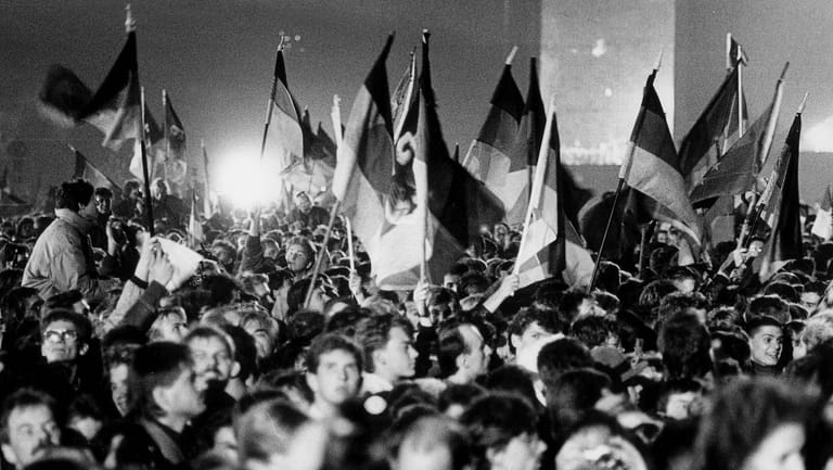 Die Menschen feiern in der Nacht vom 2. auf den 3. Oktober 1990 das Fest der Einheit vor dem Reichstag in Berlin.