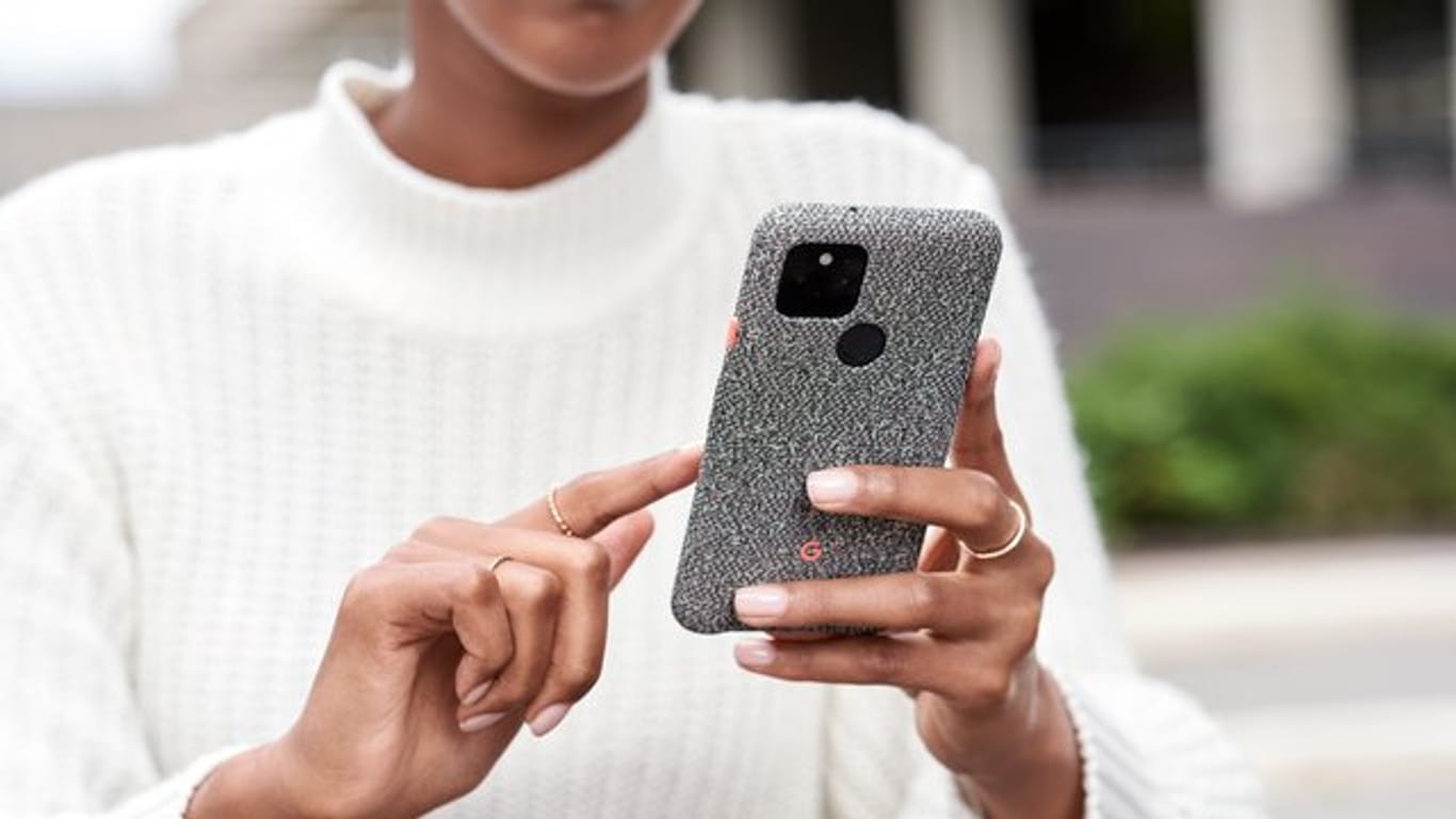 Eine Frau hält ein Pixel-Smartphone von Google in den Händen.