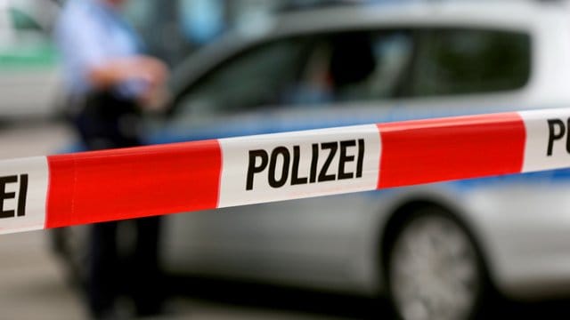 Ein Einsatzfahrzeug der Polizei hinter einer Polizeiabsperrung.