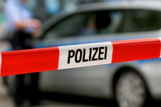 Ein Einsatzfahrzeug der Polizei hinter einer Polizeiabsperrung.