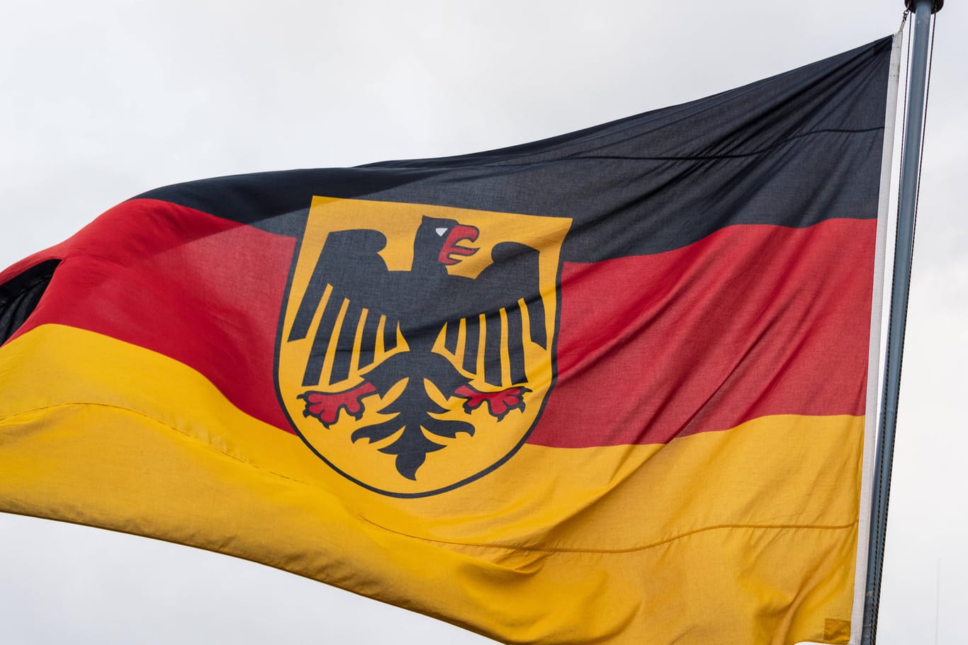 Flagge der Bundesrepublik Deutschland weht im Wind (Symbolbild): Sie ist ein deutsches Hoheitszeichen und Staatssymbol.