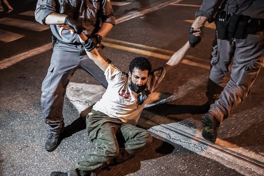 Die Polizei verhaftet während einer Protestaktion einen Demonstranten.