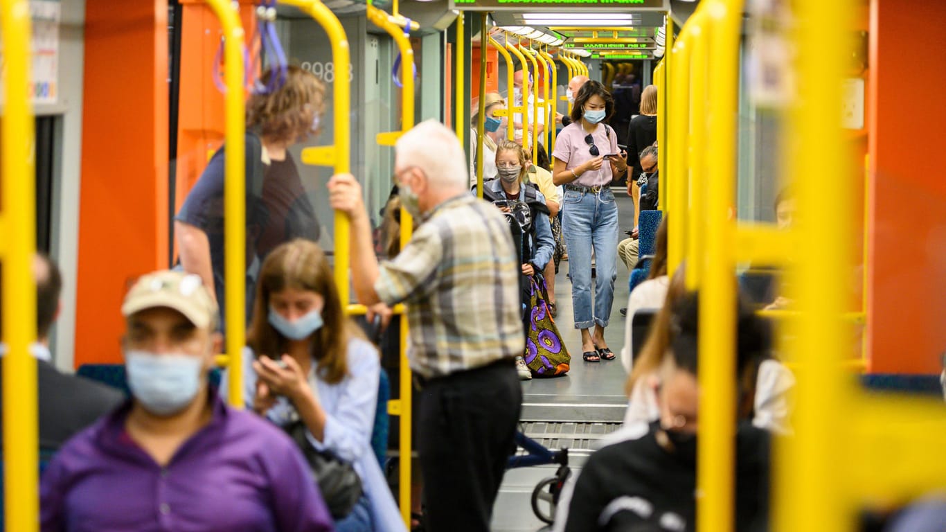 Menschen mit Masken sitzen in einem Waggon (Archivbild): In Frankfurt ist die Zahl der Neuinfektionen angestiegen.