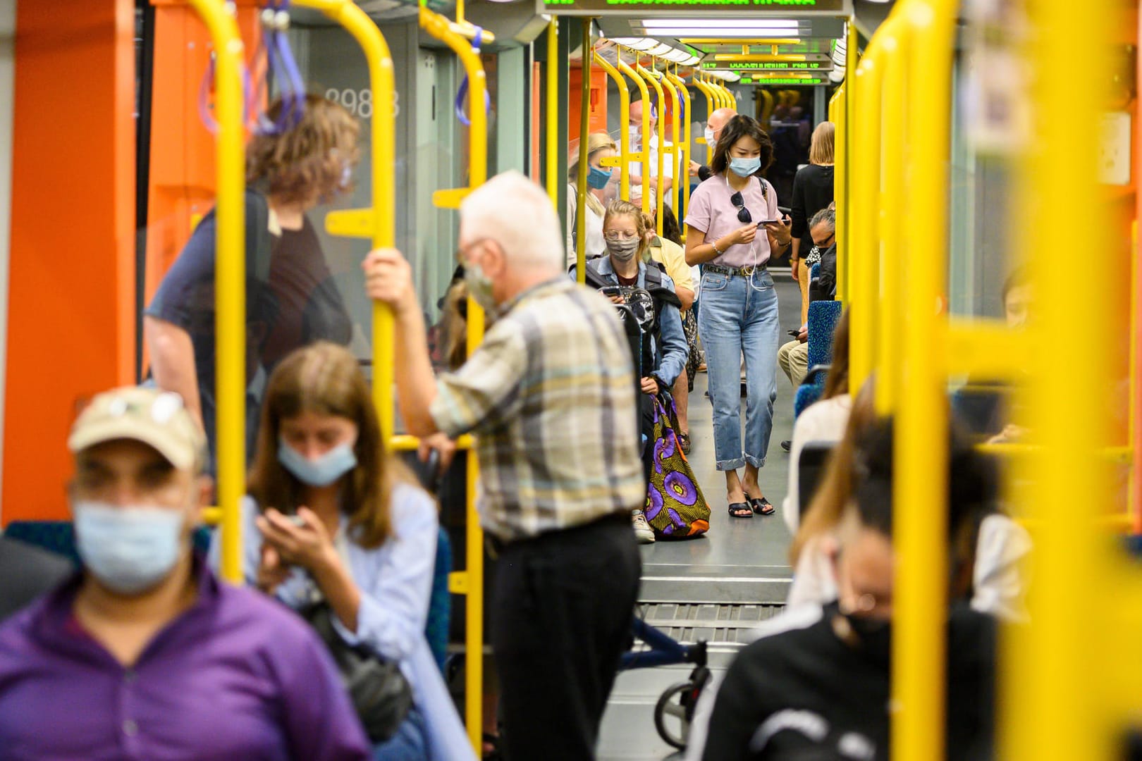 Menschen mit Masken sitzen in einem Waggon (Archivbild): In Frankfurt ist die Zahl der Neuinfektionen angestiegen.