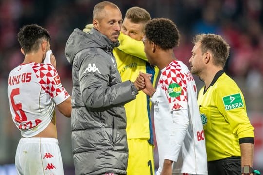 Nach der Niederlage klatscht der Mainzer Interimstrainer Jan-Moritz Lichte (M) mit den Spielern ab.