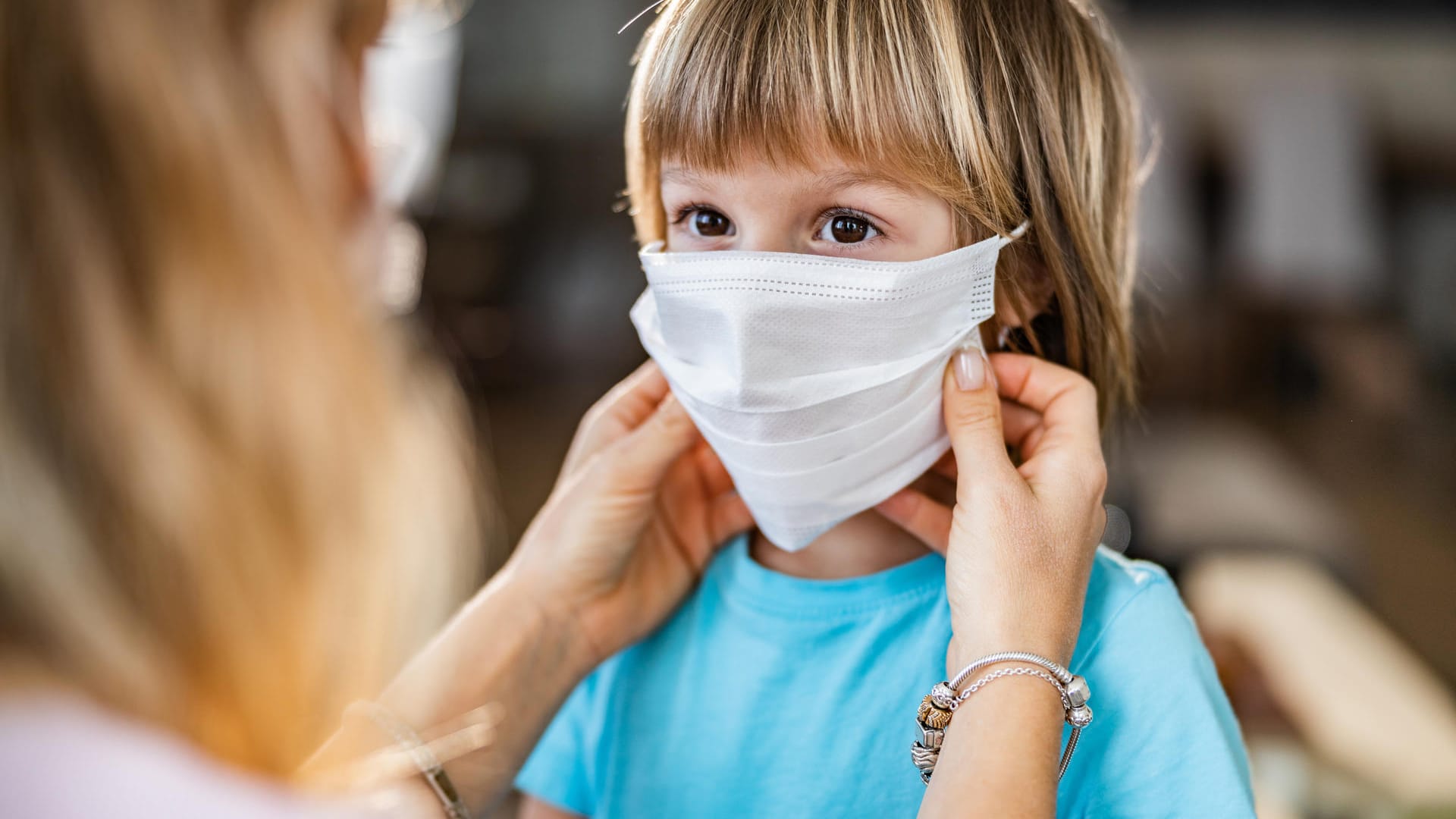 Kind mit Maske: In Corona-Zeiten ist die Maske für viele Schulkinder in Deutschland ein treuer Begleiter. Doch ist das Tragen von Masken für Kinder gefährlich?