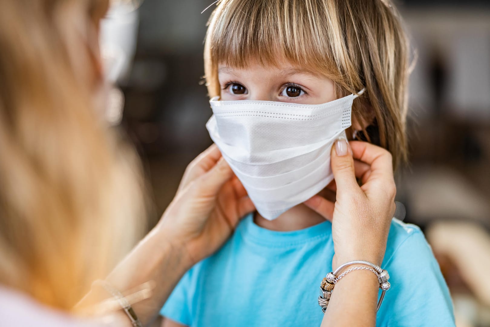 Kind mit Maske: In Corona-Zeiten ist die Maske für viele Schulkinder in Deutschland ein treuer Begleiter. Doch ist das Tragen von Masken für Kinder gefährlich?